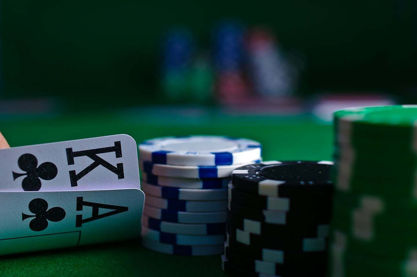 Mano che tiene Re e Asso di Fiori su fiches da casinò.