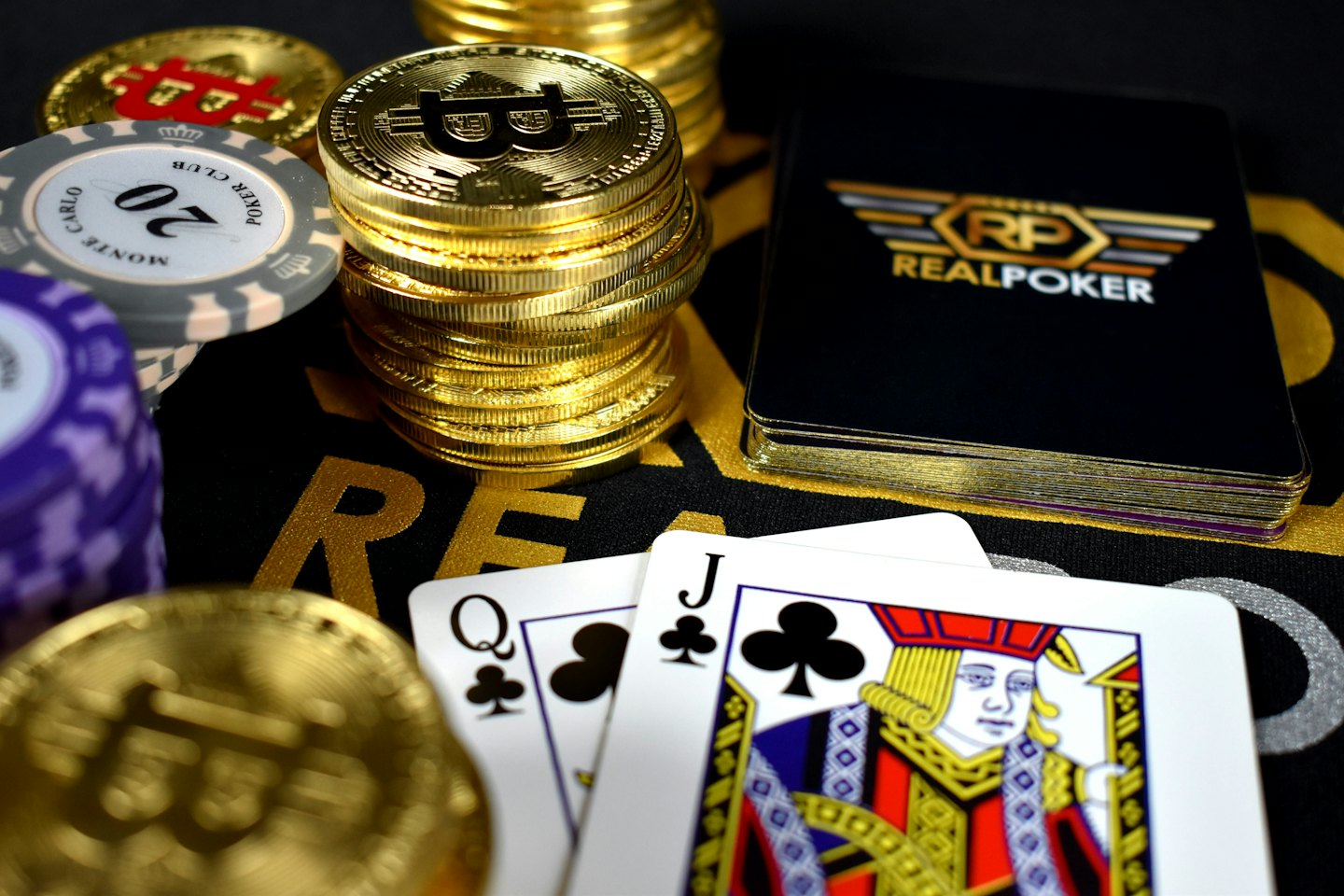 Carte da gioco e monete d'oro di criptovaluta su un tavolo da gioco.