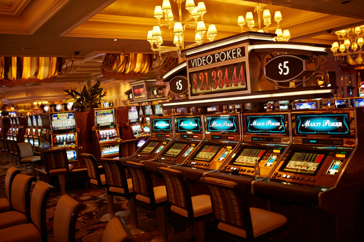 File di slot machine vuote in un casinò illuminato.