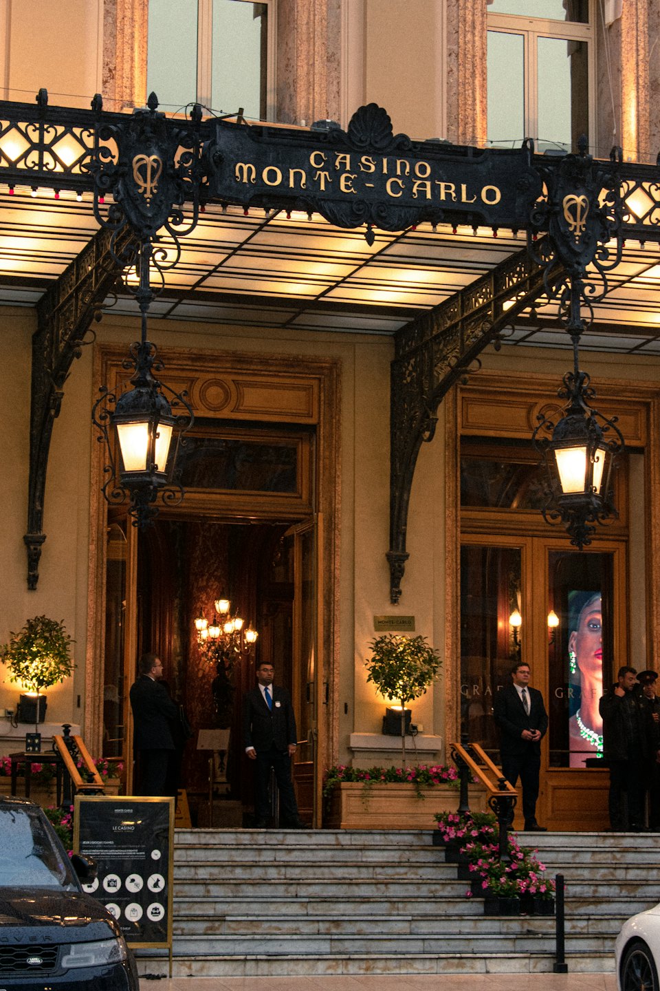 Personale in piedi davanti all'ingresso ornato del Casinò di Monte-Carlo.