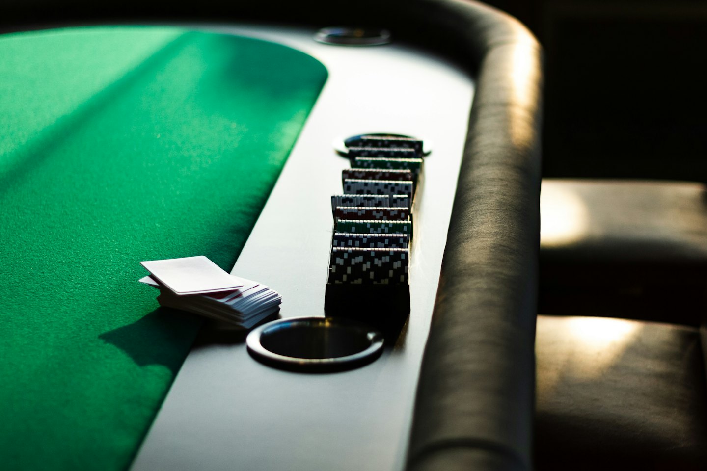 Carte da gioco e fiches da poker su un tavolo di legno.