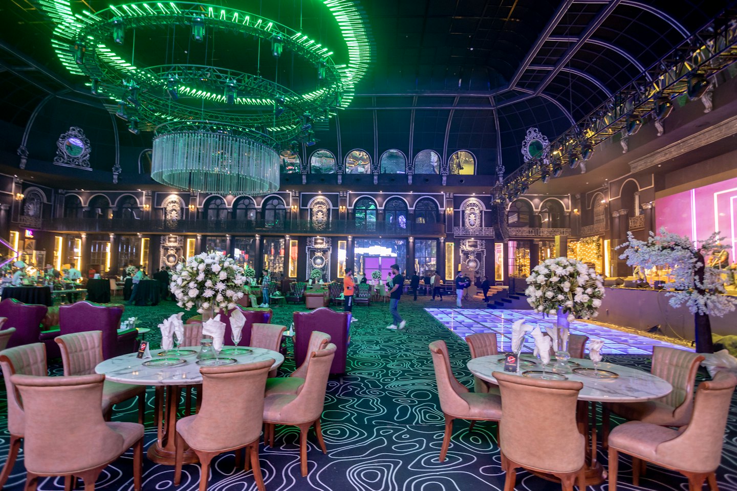 Elegante sala per eventi con tavoli in marmo e un grande lampadario di cristallo.